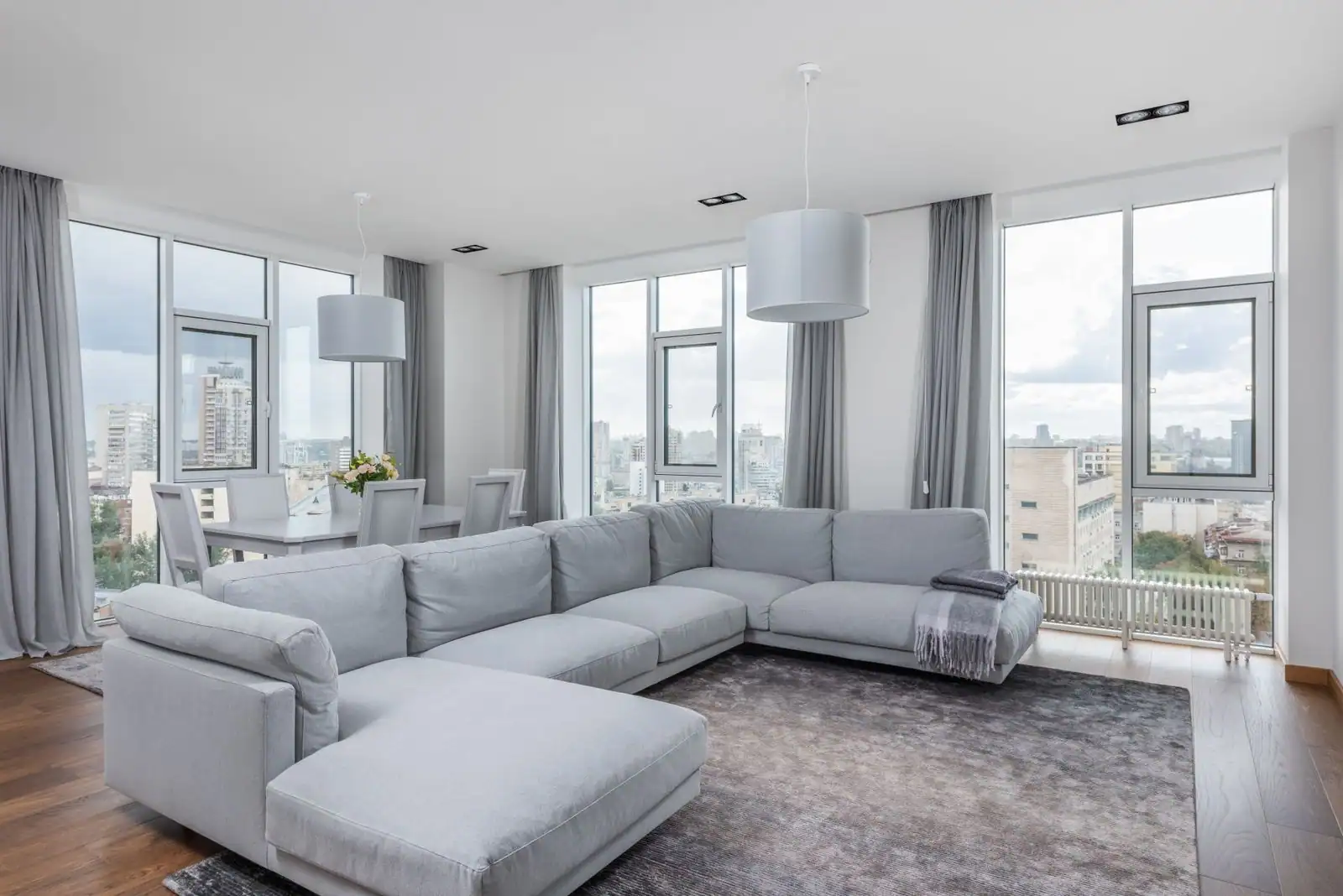Salon lumineux d'un appartement avec canapé et grandes fenêtres