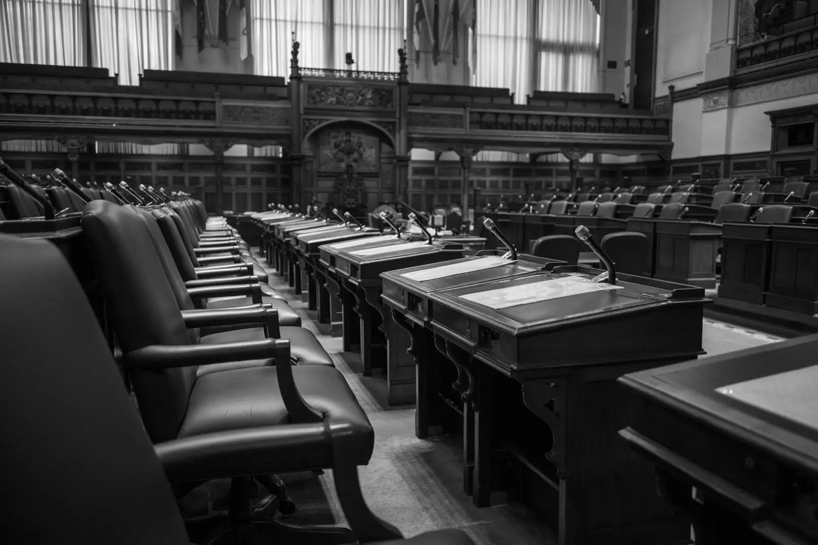 Enceinte vide d'une assemblée parlementaire, avec ses rangées de pupitres et de sièges