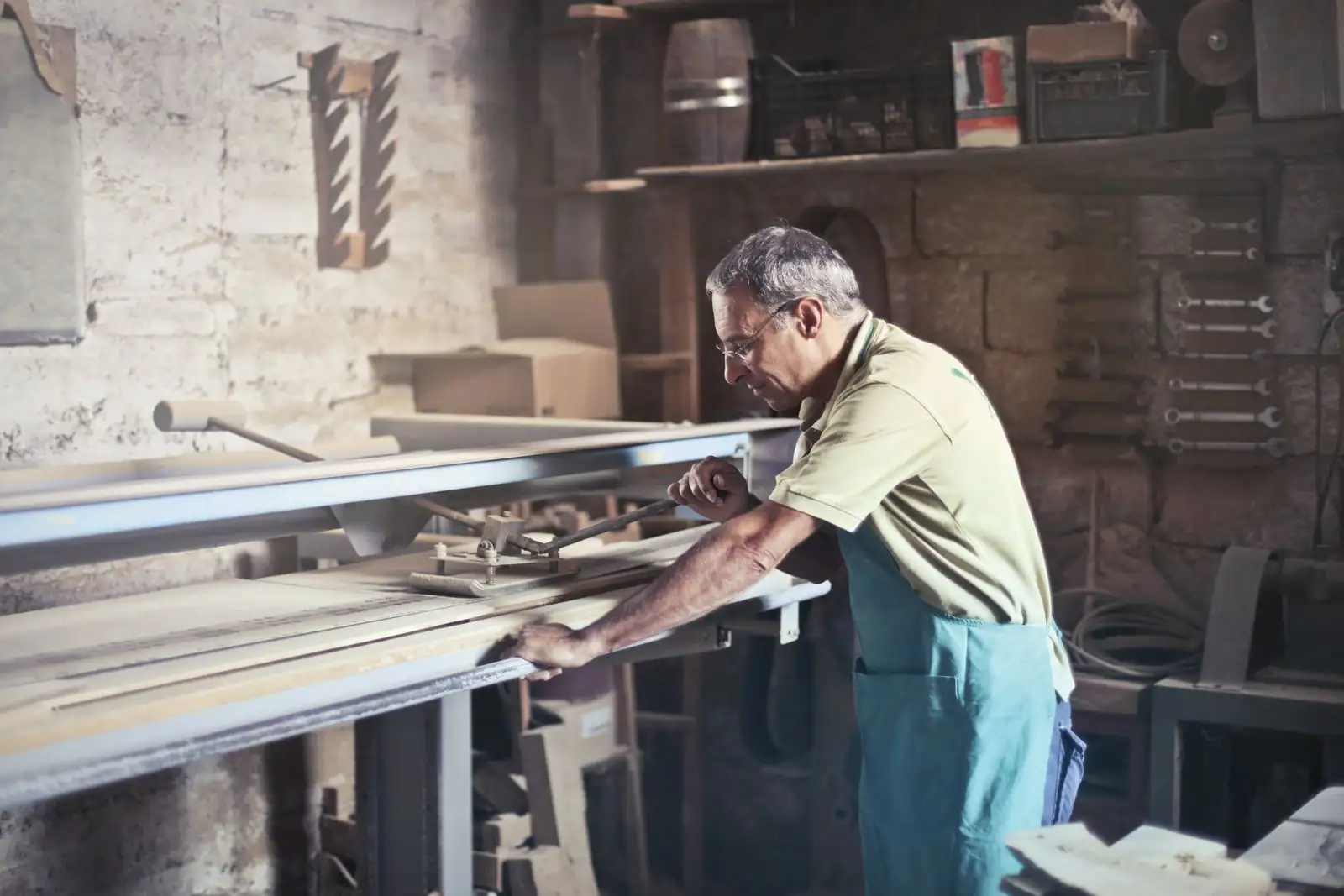 Artisan concentré au travail dans son atelier, entouré de ses outils de métier