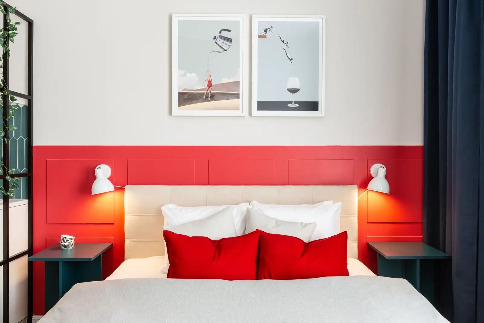 Chambre contemporaine avec un soubassement de mur rouge vif et des coussins rouges sur un lit clair
