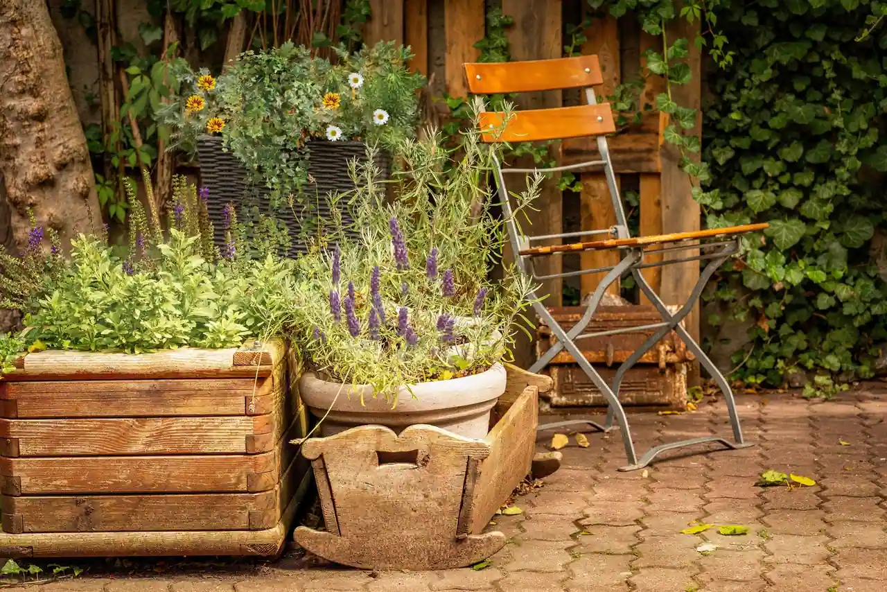 Jardin décoré avec des objets de récupération, jardinières en bois et caisses plantées