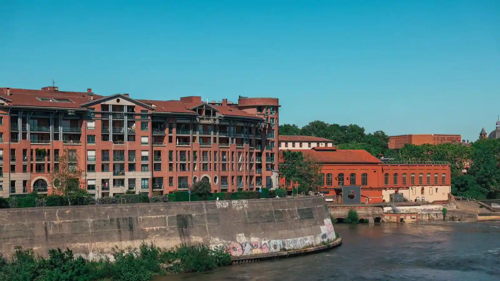 Immeubles d'habitation en brique le long de la Garonne à Toulouse, illustrant le marché locatif de la ville.