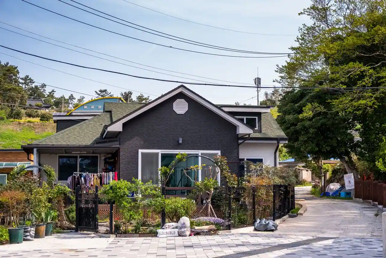 Maison individuelle avec jardin clôturé et allée pavée menant à l'entrée