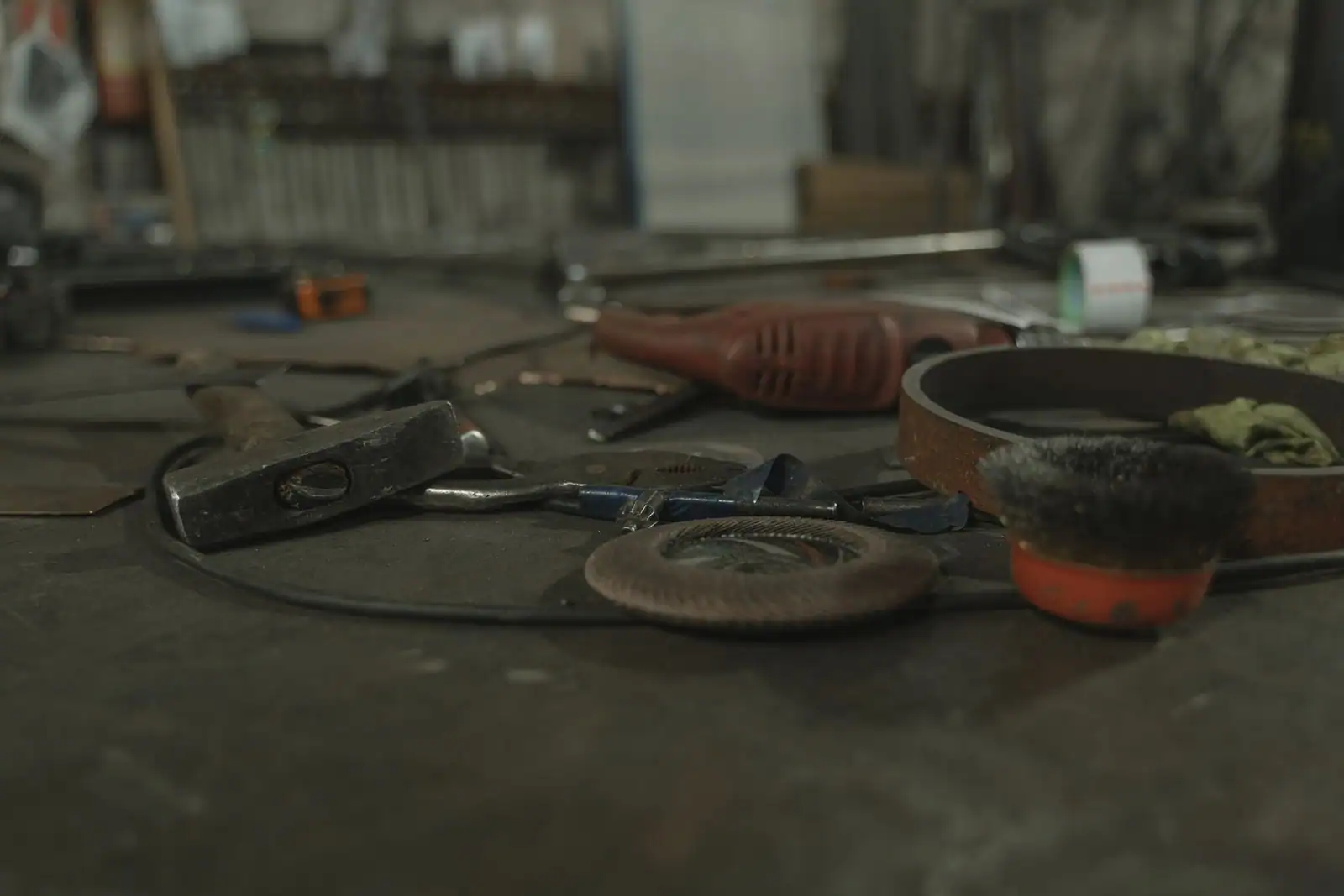 Assortiment d'outils manuels et d'un outil électroportatif posés sur l'établi d'un atelier.
