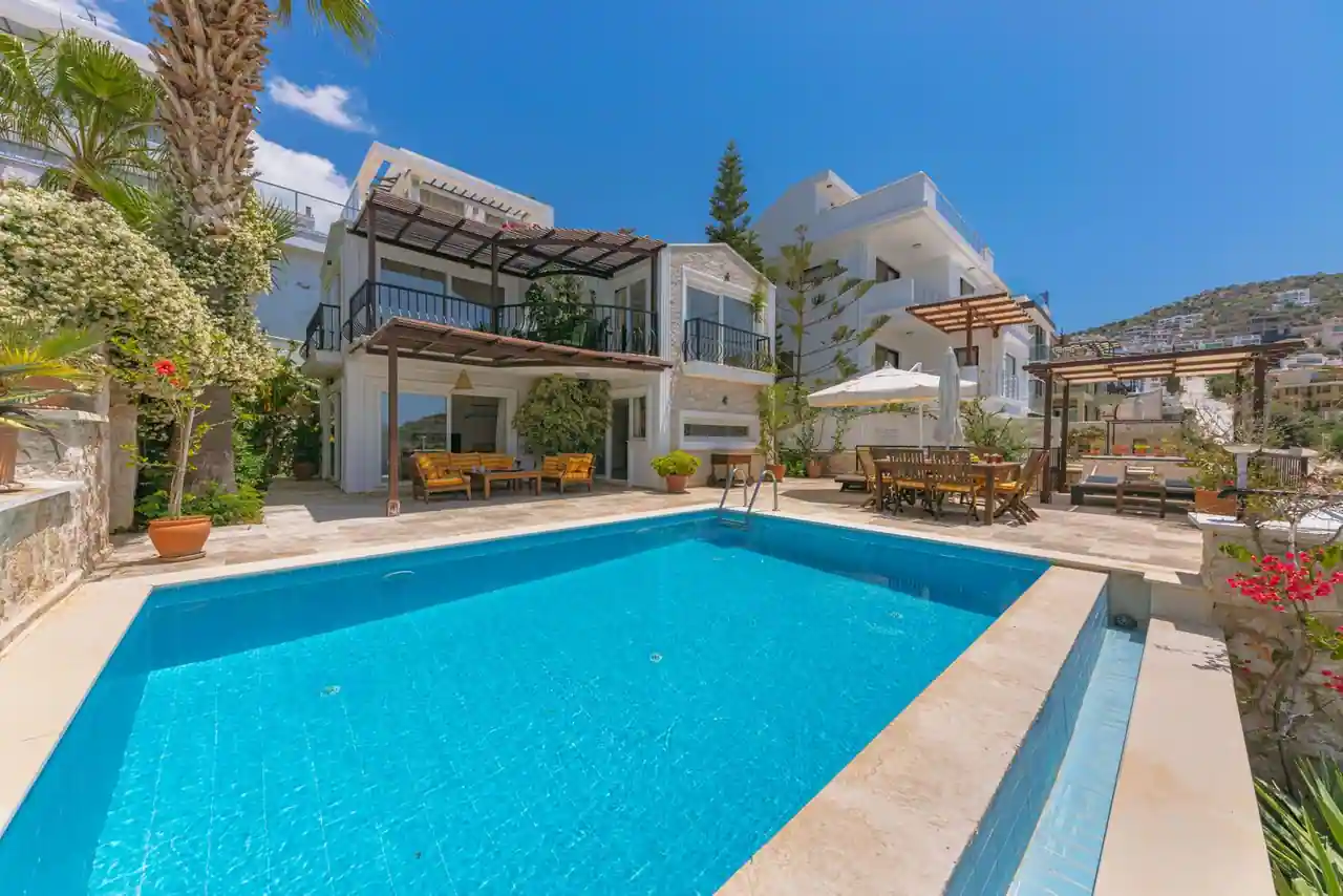 Piscine extérieure d'une maison méditerranéenne avec terrasse claire en plein soleil