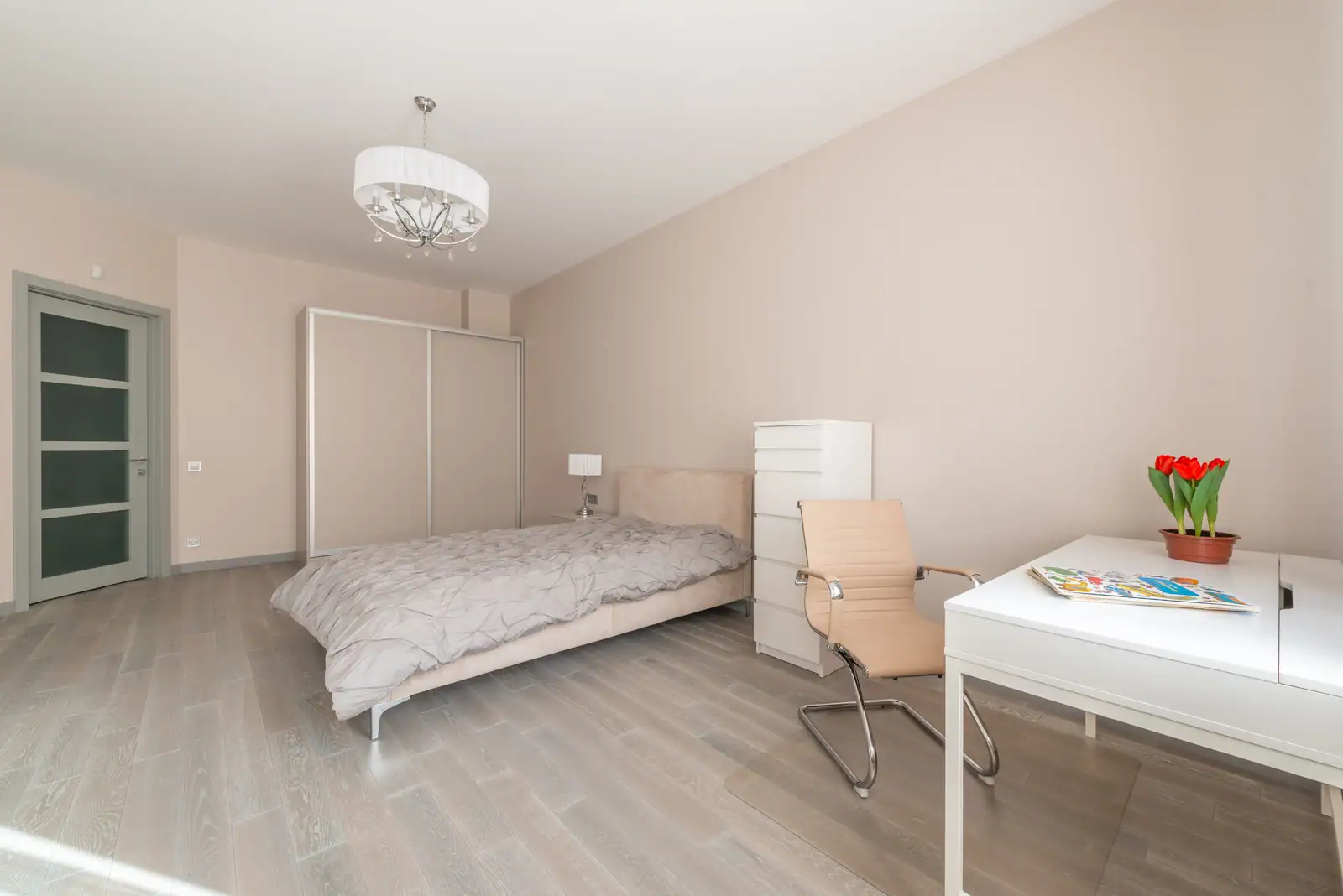 Chambre au sol dégagé de part et d’autre du lit, armoire à portes coulissantes et parquet sans tapis