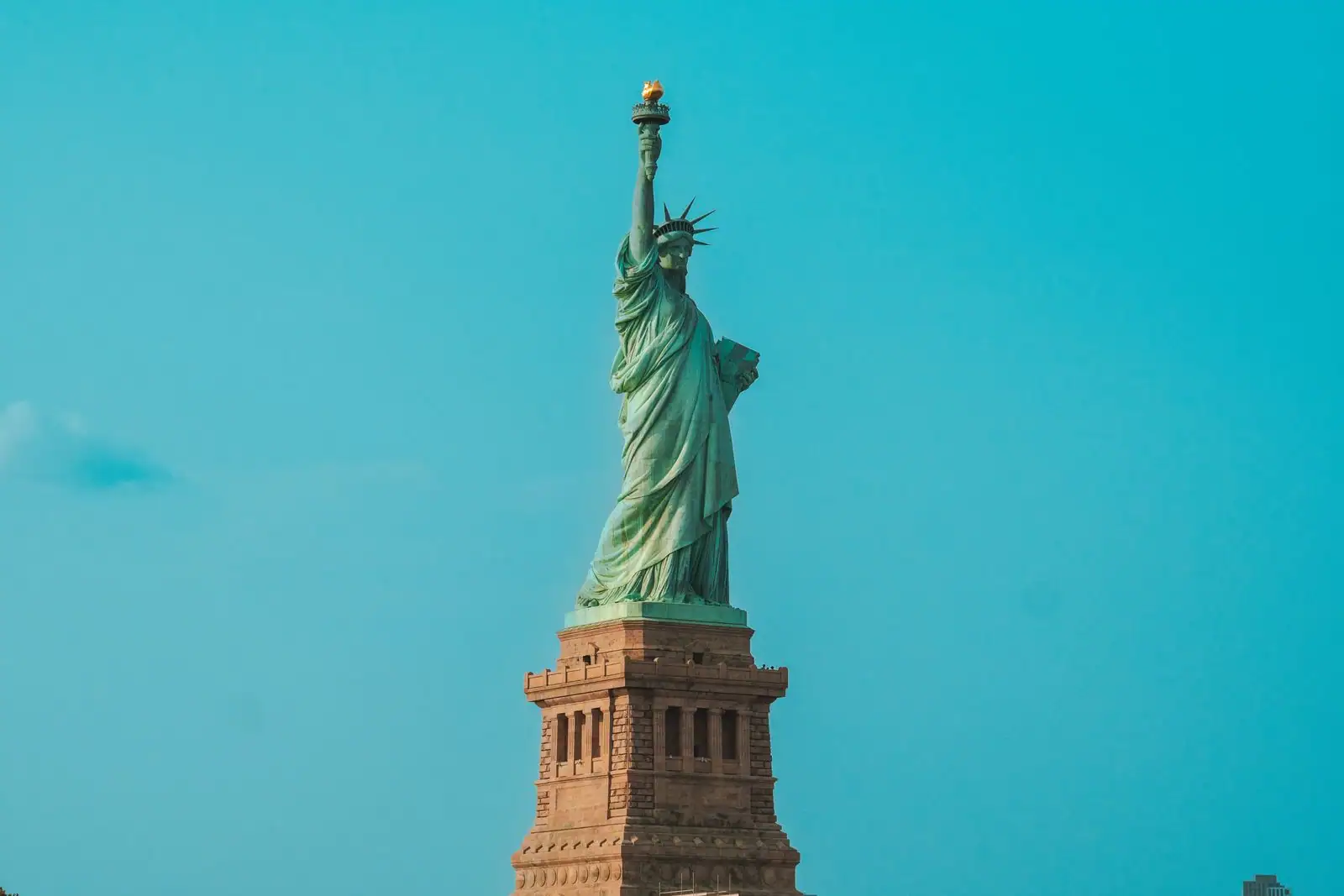 La statue de la Liberté et sa peau de cuivre couverte d'une patine vert-de-gris, sous un ciel dégagé